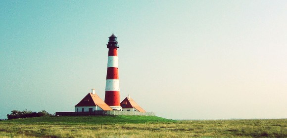 Twee zorgmedewerkers buiten in blauwe uniformen. Op achtergrond twee ronde elementen met tekst mooie dag en mooie baan.