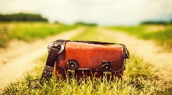 Een zorgmedewerker helpt een oudere man in een comfortabele stoel.